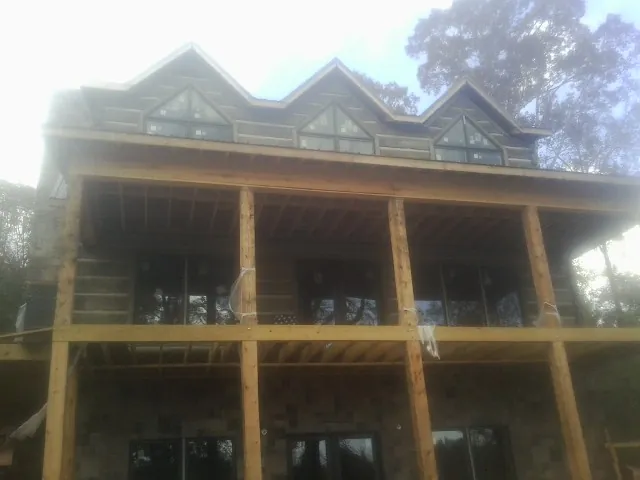Dormers and porch framing on a large log home under construction — Roof Coating work by our crew in Newport Coast