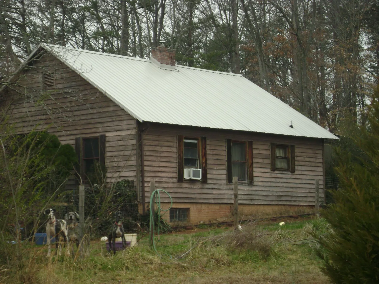 White metal roof on an old wood sided farmhouse, from a Metal Roof Installation job in Newport Coast